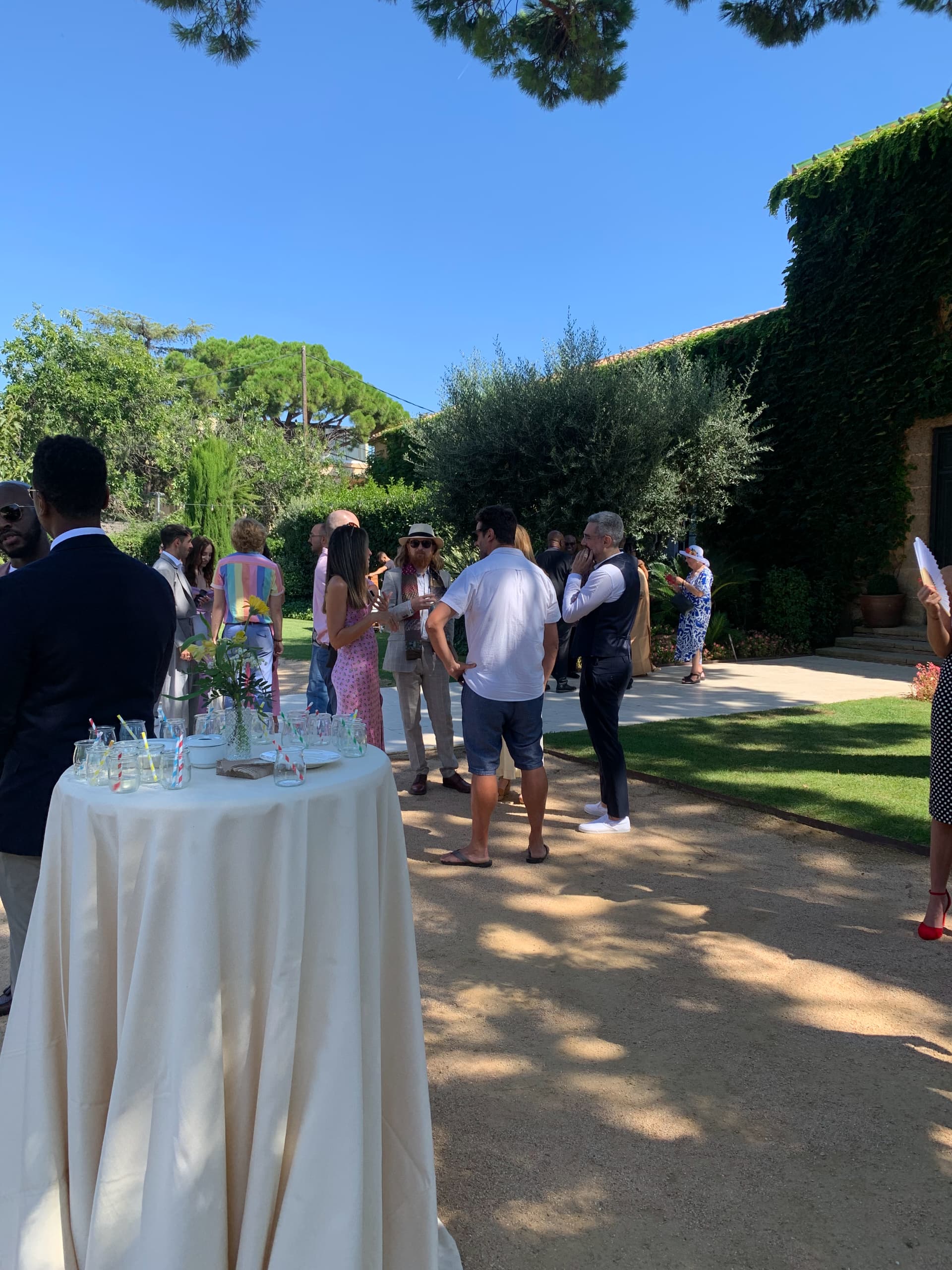 Elegant outdoor wedding reception with guests mingling in Mediterranean garden setting