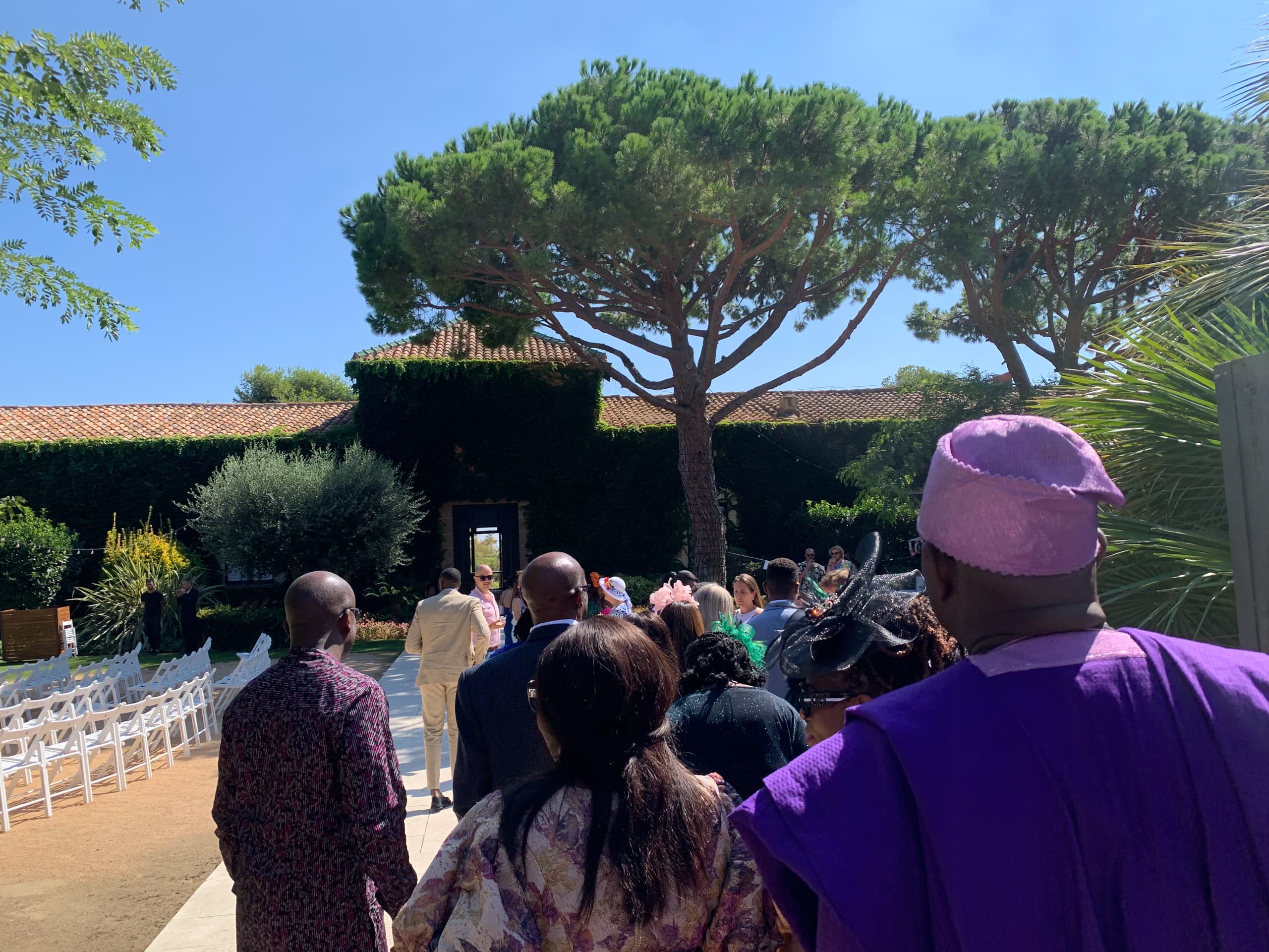 Elegant outdoor wedding venue setup with white chairs and Mediterranean architecture