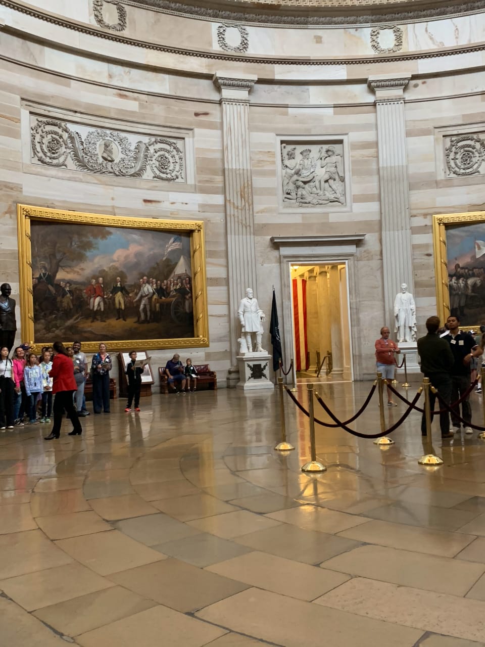 U.S. Capitol Rotunda with paintings and visitors